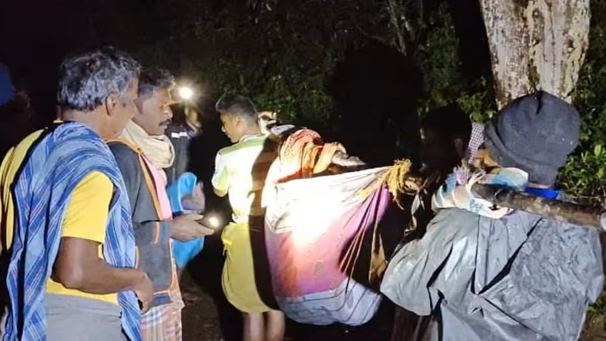 People carried a woman from Alakattu hill village to treatment in a “doli” stretcher.